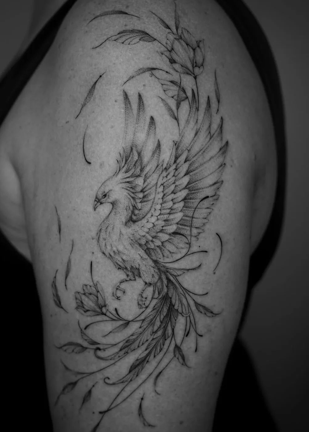 Fine line phoenix tattoo with dotwork on the upper arm