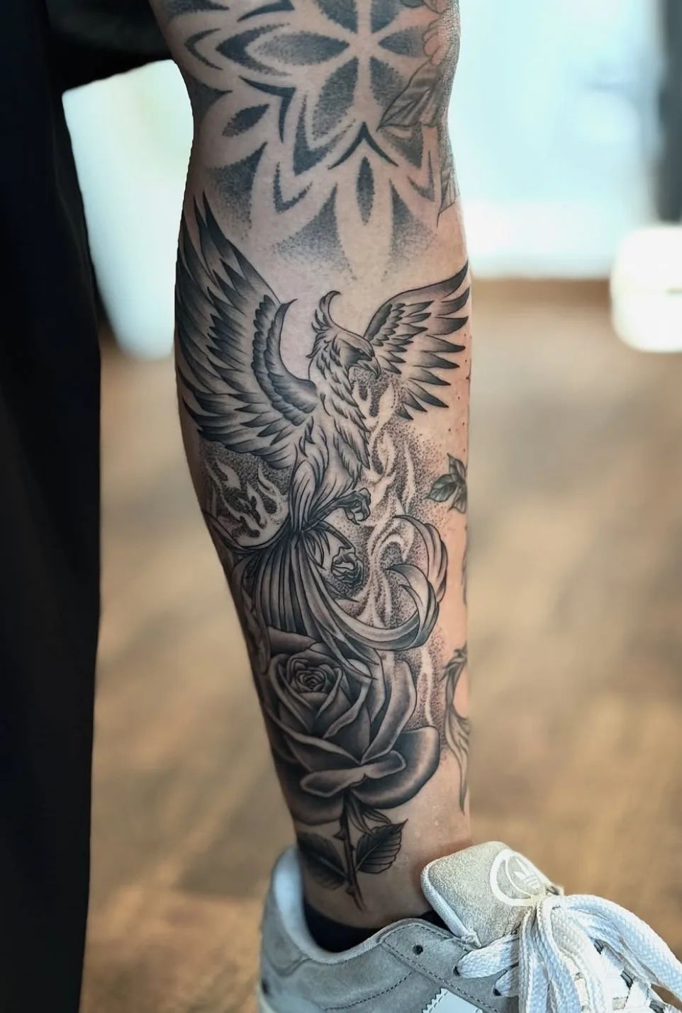 Phoenix tattoo with roses and dotwork on leg