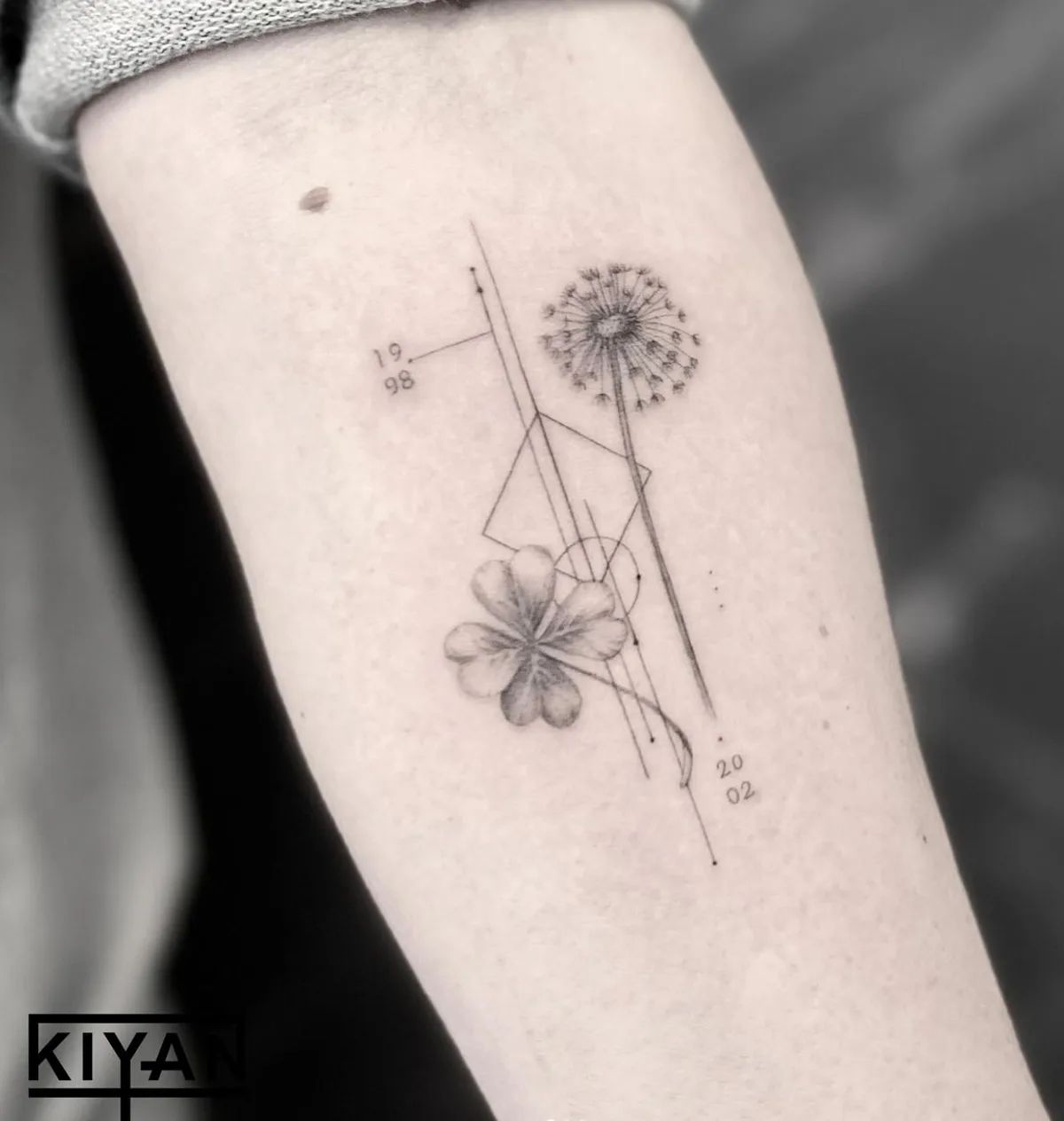 Dandelion and clover tattoo fine line with geometric elements on forearm