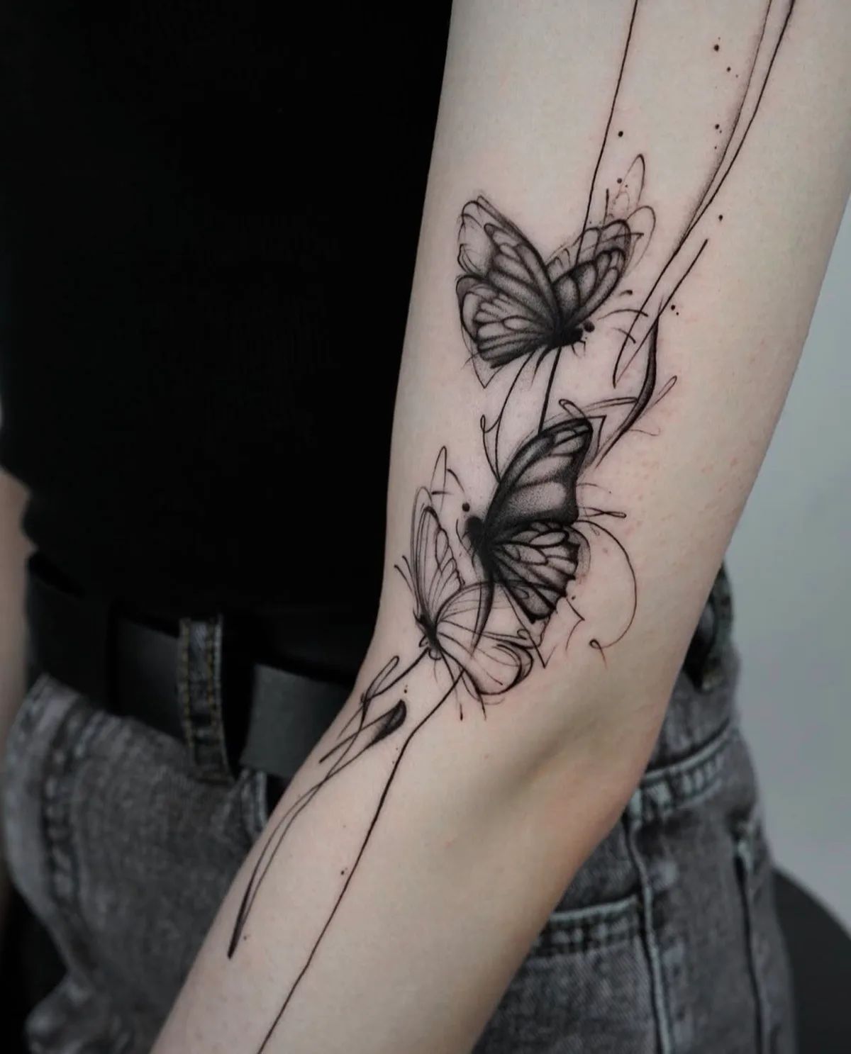 Schmetterling Tattoo im Fineline und Sketch-Stil am Oberarm