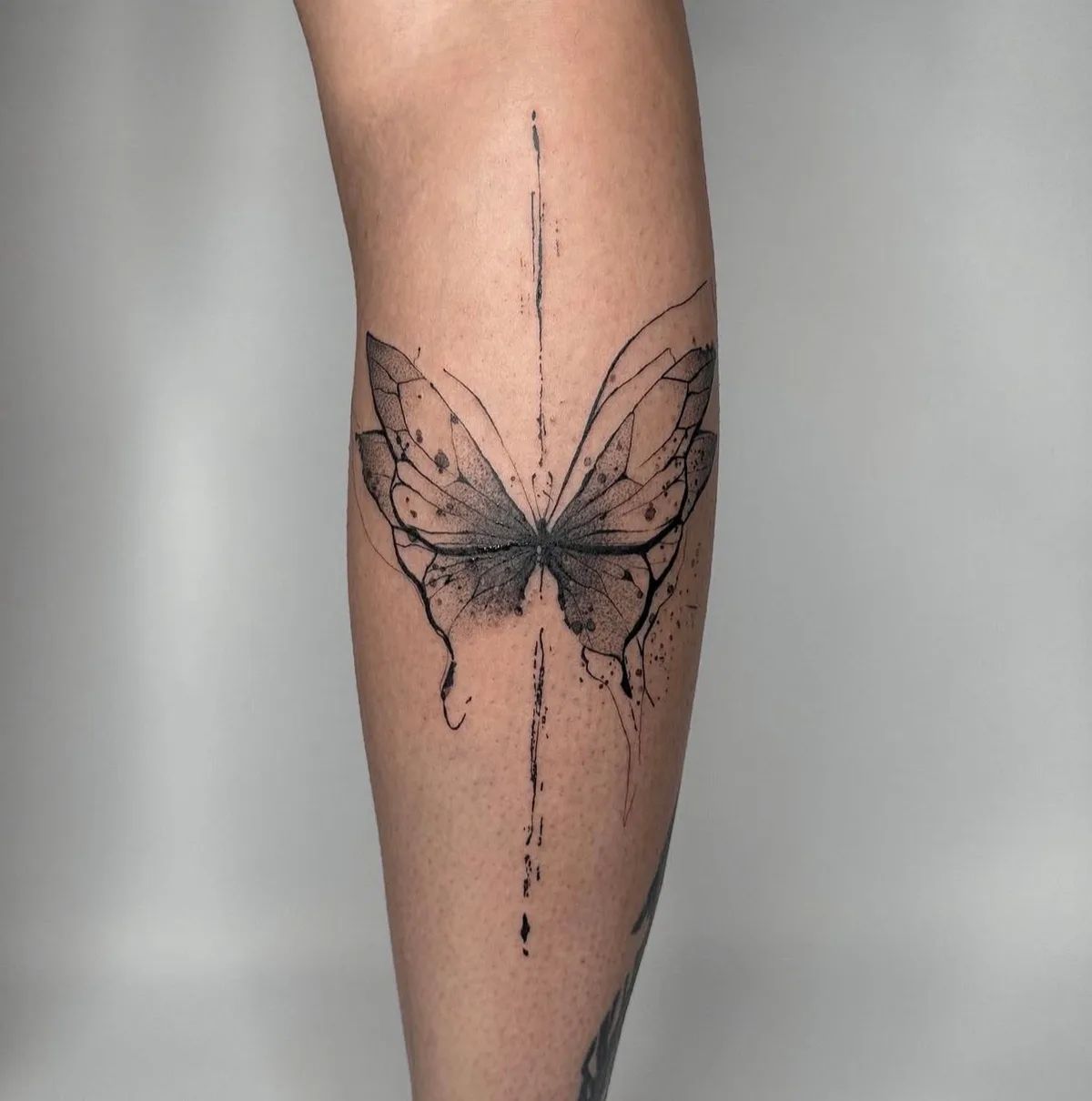 Schmetterling Tattoo im Trash Polka Stil am Unterschenkel