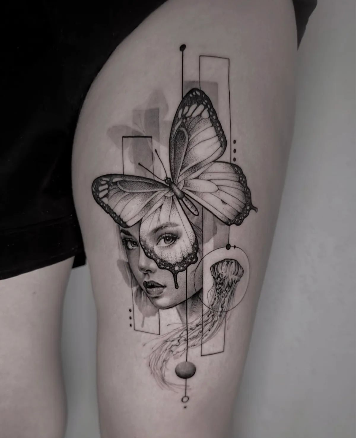 Schmetterling Tattoo mit Frauengesicht und Qualle im Fineline-Stil am Oberschenkel