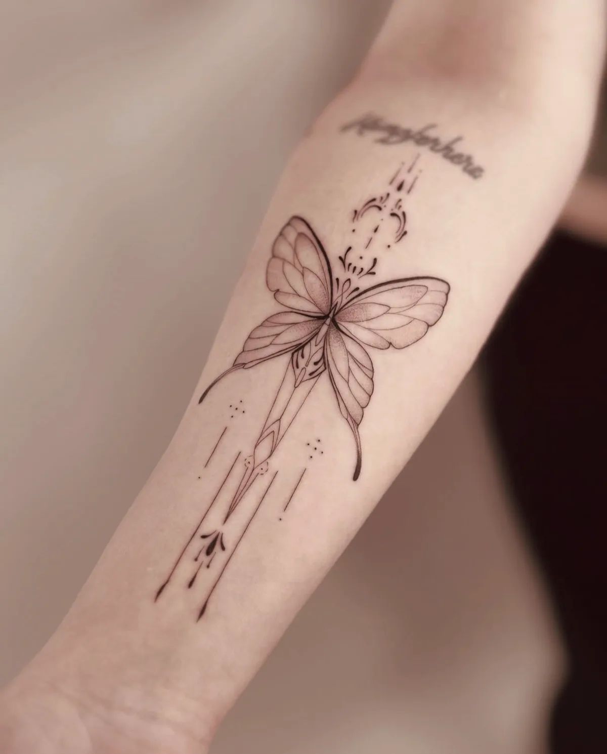 Filigranes Schmetterling Tattoo im Fineline-Stil am Unterarm