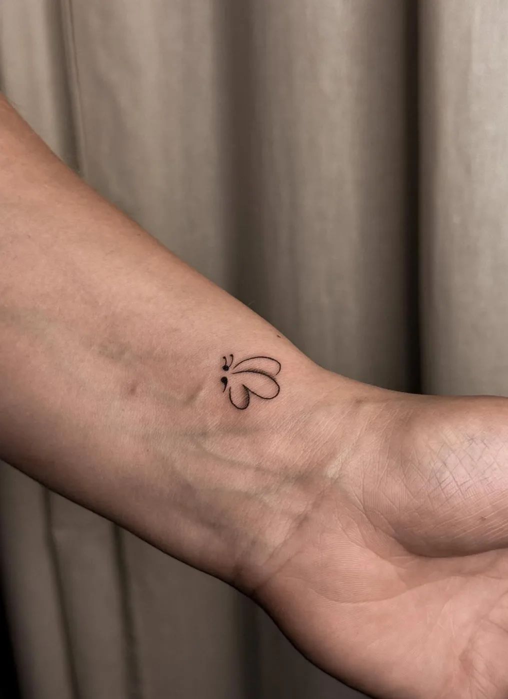 Fine line semicolon butterfly tattoo on wrist