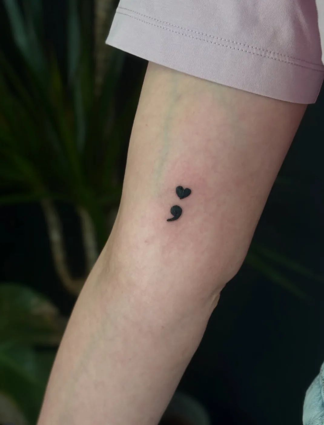 Semicolon tattoo with heart in fine line style on upper arm