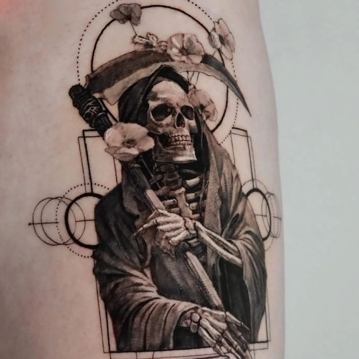 Grim Reaper tattoo with skull, scythe, and flowers in fine line style on arm
