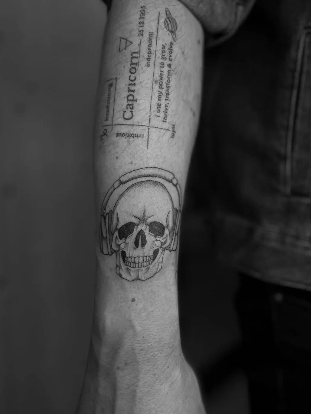 Skull with headphones fine line tattoo on forearm