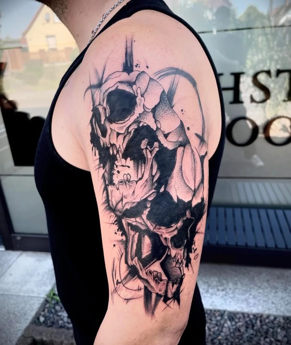 Skull tattoo in Trash Polka style on upper arm